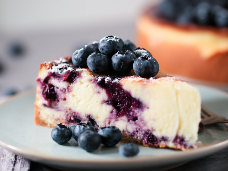 A piece of blueberry sour cream cheesecake.
