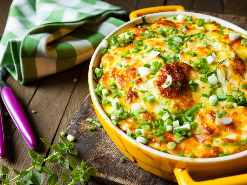 Yellow baking dish with a potato and zucchini casserole.
